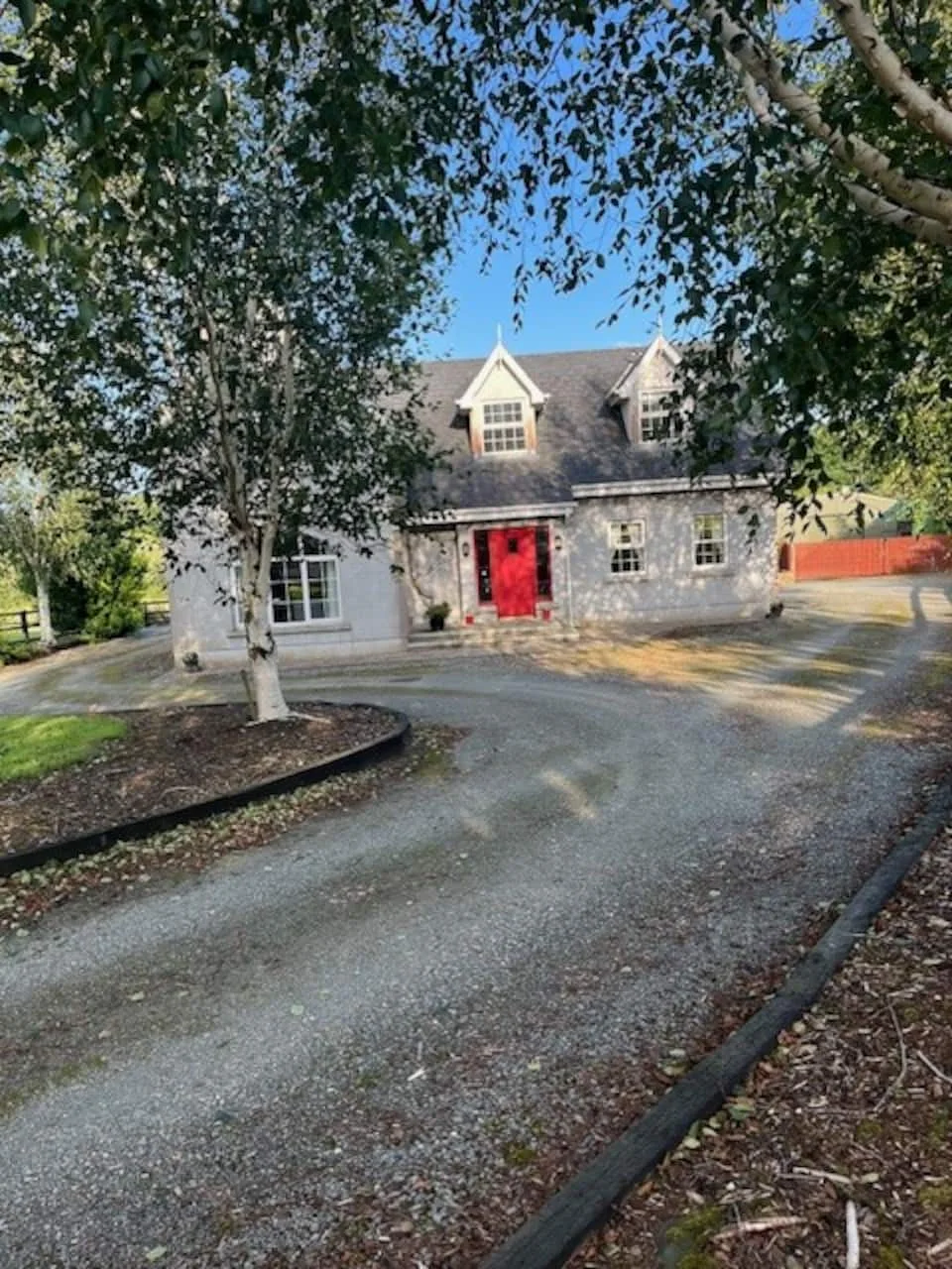 Vinny’s stone-fronted house with a red front door and a tree-lined driveway
